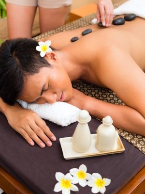 indonesian-asian-man-wellness-beauty-day-spa-having-hot-stone-massage-treatment-looking-relaxed_79405-13018