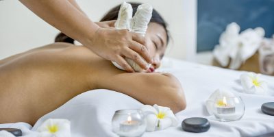 portrait of young beautiful woman in spa environment, massage wi